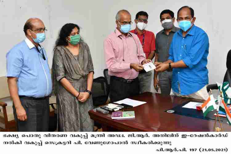 Secretary P venugopal receives Minister GR Anil presenting e- ration card