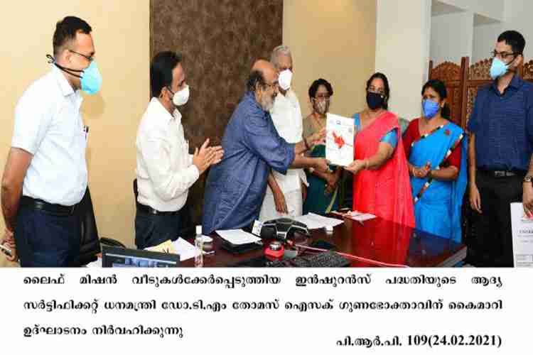Minister Dr. T. M. Thomas Isaac presents Life Mission Insurance to beneficiarees